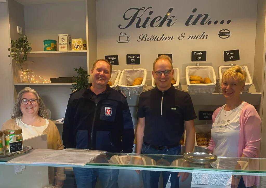 Verkaufstresen und Brötchenregal mit Mitgliedern des Bürgervereins, die Brötchen verkaufen.